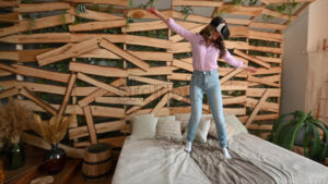 VIDEO Woman looking through VR headset and jumping on bed - Starpik