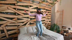 VIDEO Woman looking through VR headset and jumping on bed - Starpik