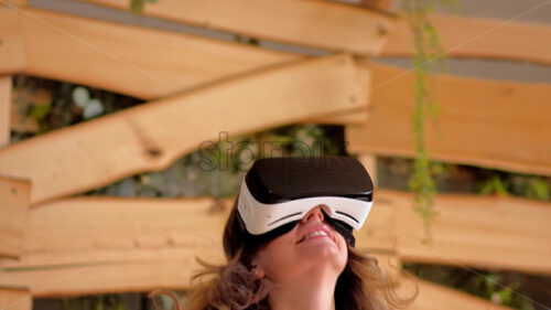 VIDEO Woman looking through VR headset and jumping on bed - Starpik