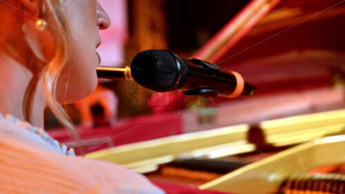 VIDEO Woman singing into the microphone and playing a red piano - Starpik