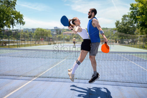 Couple playing pickleball at daylight. Celebrating victory - Starpik