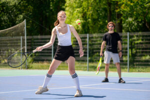 Happy young couple playing tennis in the park - Starpik
