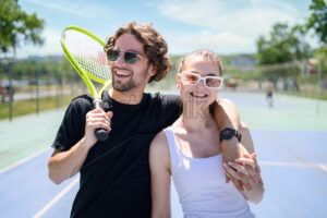 Portrait of a happy young couple holding tennis rackets - Starpik