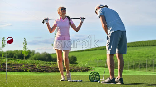 VIDEO A man and a woman playing golf on a sunny day - Starpik