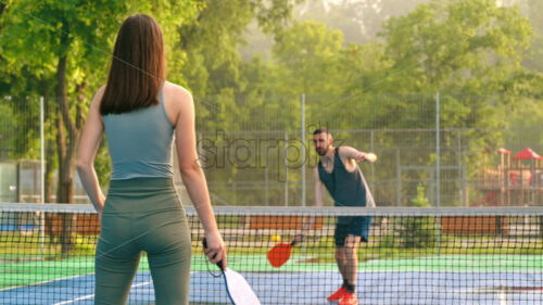 VIDEO A man and a woman playing pickleball at sunrise, after rain - Starpik