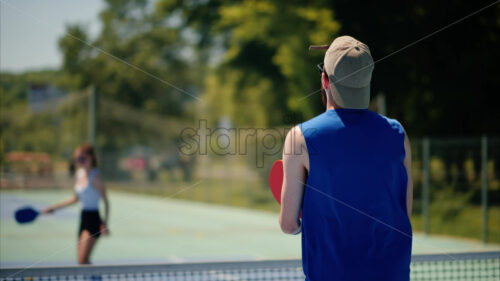 VIDEO A man and a woman playing pickleball on a sunny day - Starpik