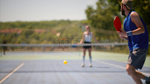 VIDEO A man and a woman playing pickleball on a sunny day - Starpik