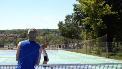 VIDEO A man and a woman playing pickleball on a sunny day - Starpik