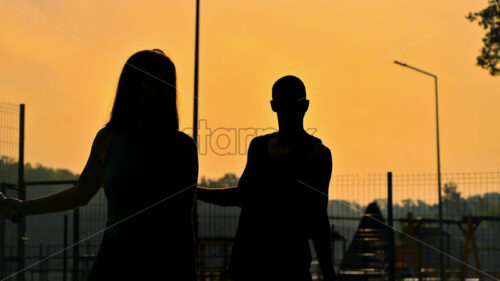 VIDEO A man and a woman playing tennis at sunset, after rain - Starpik