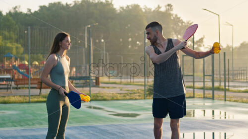 VIDEO A man teaching a woman how to play pickleball after rain - Starpik