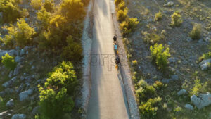 VIDEO Aerial, drone view of people with yellow backpacks biking on the road in Albania - Starpik