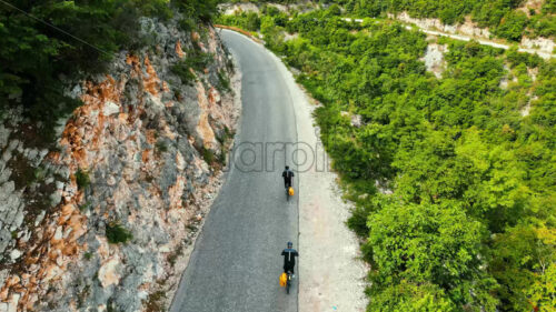 VIDEO Aerial, drone view of people with yellow backpacks biking on the road in Bosnia and Herzegovina - Starpik