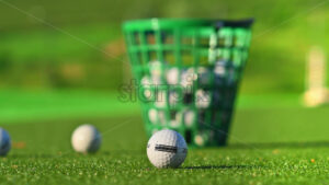 VIDEO Close up of a green bucket filled with golf balls on a course, on a sunny day - Starpik
