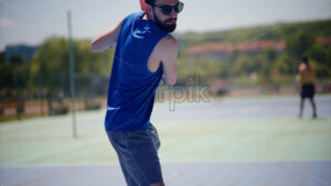 VIDEO Close up of a man in a blue shirt playing pickleball with a red racket on a sunny day - Starpik