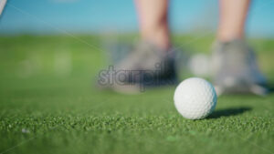 VIDEO Close up of a man practicing hitting a golf ball with a club on the course - Starpik
