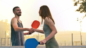 VIDEO Man and woman shaking hands after playing pickleball at sunrise, after rain - Starpik