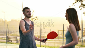 VIDEO Man and woman shaking hands after playing pickleball at sunrise, after rain - Starpik