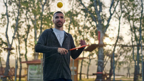 VIDEO Man in zip up hoodie playing pickleball with a red racket after rain - Starpik