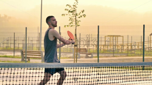 VIDEO Man playing pickleball with a red racket at sunrise, after rain - Starpik