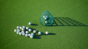 VIDEO Multiple golf balls near a green bucket on a course, on a sunny day - Starpik