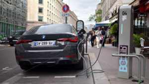 VIDEO Paris, France – June 18, 2024: Back view of a black BMW i4 car charging on the street - Starpik