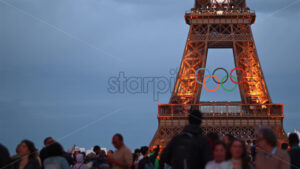 VIDEO Paris, France – June 18, 2024: People passing by the Eiffel Tower with the Olympic Games sign sparkling in the evening - Starpik