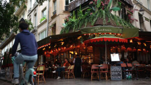 VIDEO Paris, France – June 18, 2024: People walking by a corner bistro with sidewalk tables - Starpik