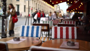 VIDEO Tables at a cafe with blurred people walking in the rain on the background - Starpik