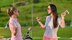 VIDEO Two woman holding golf clubs on their shoulders and high fiving each other on a sunny day - Starpik