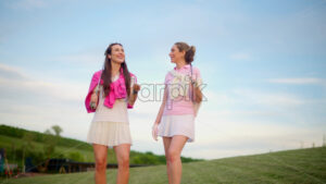 VIDEO Two women in white and pink clothes playing with a white golf ball on the course - Starpik