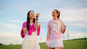 VIDEO Two women in white and pink clothes playing with a white golf ball on the course - Starpik