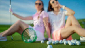 VIDEO Two women standing on the golf course near a bucket with spilled balls - Starpik