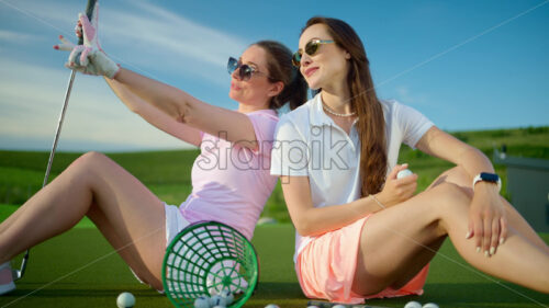 VIDEO Two women standing on the golf course near a bucket with spilled balls - Starpik