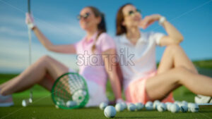 VIDEO Two women standing on the golf course near a bucket with spilled balls - Starpik