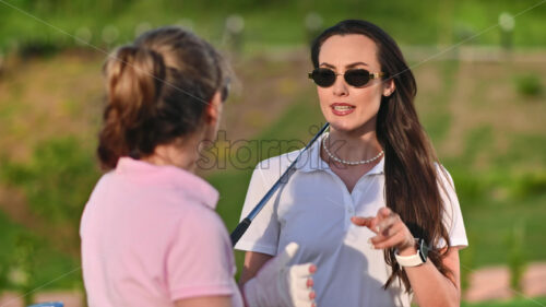 VIDEO Two women talking on the golf course on a sunny day - Starpik