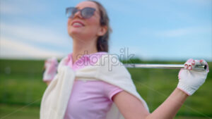 VIDEO Woman holding a golf club on her shoulders, watching the sunset - Starpik