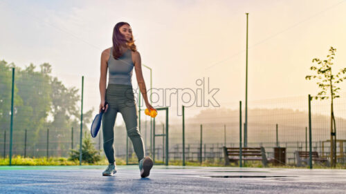 VIDEO Woman playing pickleball on a blue and green court after rain - Starpik