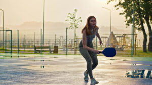 VIDEO Woman playing pickleball on a blue and green court after rain - Starpik