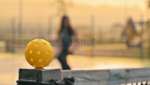 VIDEO Woman playing pickleball on a blue and green court at sunrise, after rain - Starpik