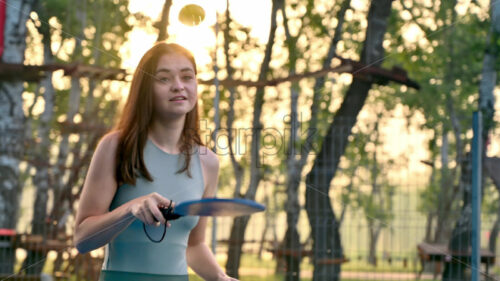 VIDEO Woman playing pickleball on a blue and green court at sunrise, after rain - Starpik