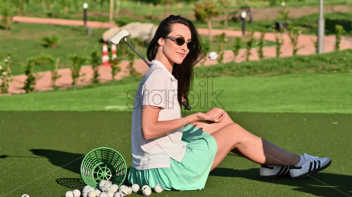 VIDEO Woman playing with a golf ball standing on the course near a bucket - Starpik