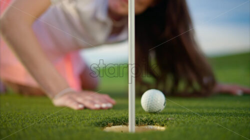 VIDEO Woman trying to push a golf ball into the hole by blowing on it - Starpik