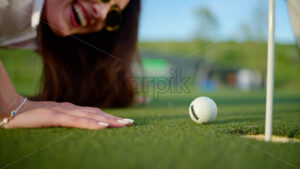 VIDEO Woman trying to push a golf ball into the hole by blowing on it - Starpik
