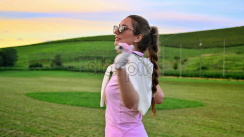 VIDEo Woman holding a golf club on her shoulders, watching the sunset - Starpik