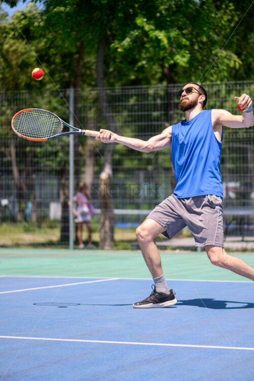 Young man playing tennis outdoor - Starpik