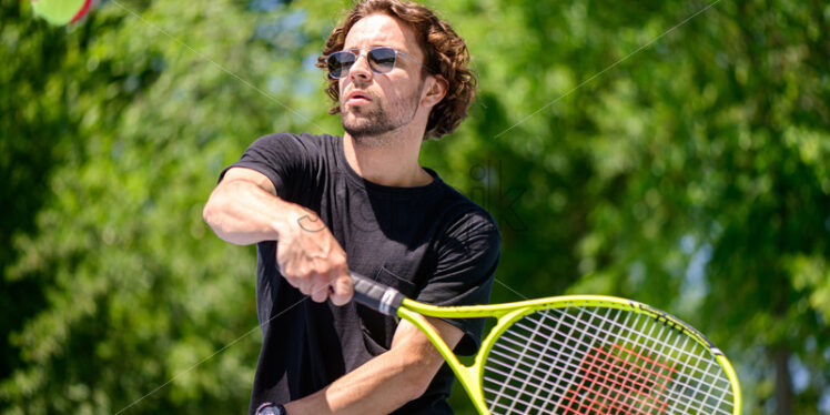 Young man playing tennis outdoor - Starpik
