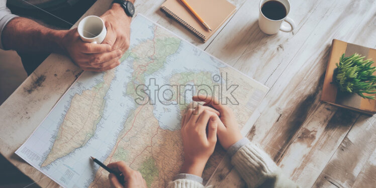 Man and woman talking travel plans map at the table top view - Starpik