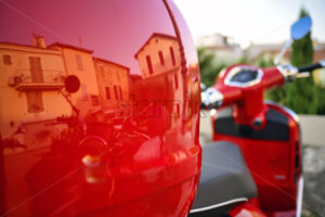 Intense red motorcycle with house and buildings reflections in Antibes, France - Starpik