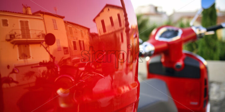 Intense red motorcycle with house and buildings reflections in Antibes, France - Starpik