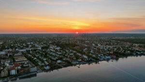 VIDEO Aerial drone view of Osterbo Nord, Nordhavn harbour area at the coast of the Oresund at sunset - Starpik